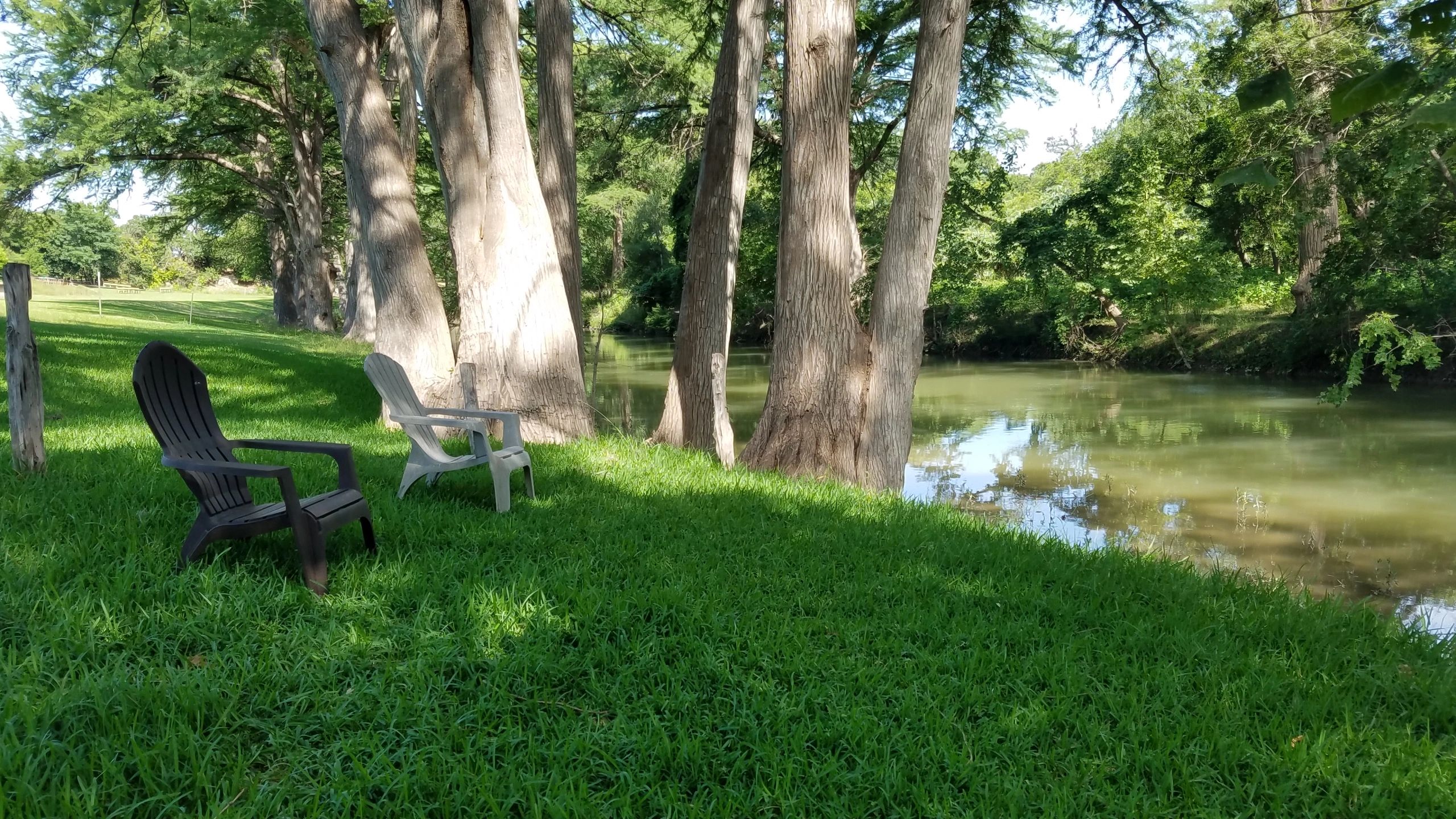 Adirondack chairs on the riverside lawn